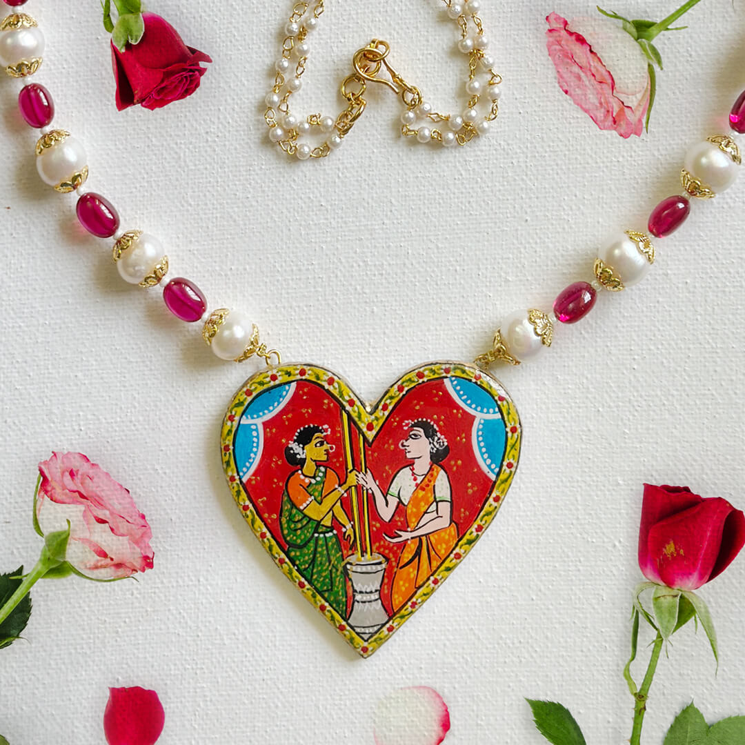Front View Necklace Set Eternal Bond Cheriyal painting necklace with heart-shaped pendant, depicting two women grinding turmeric, adorned with pearls and rubies by Bujjis.
