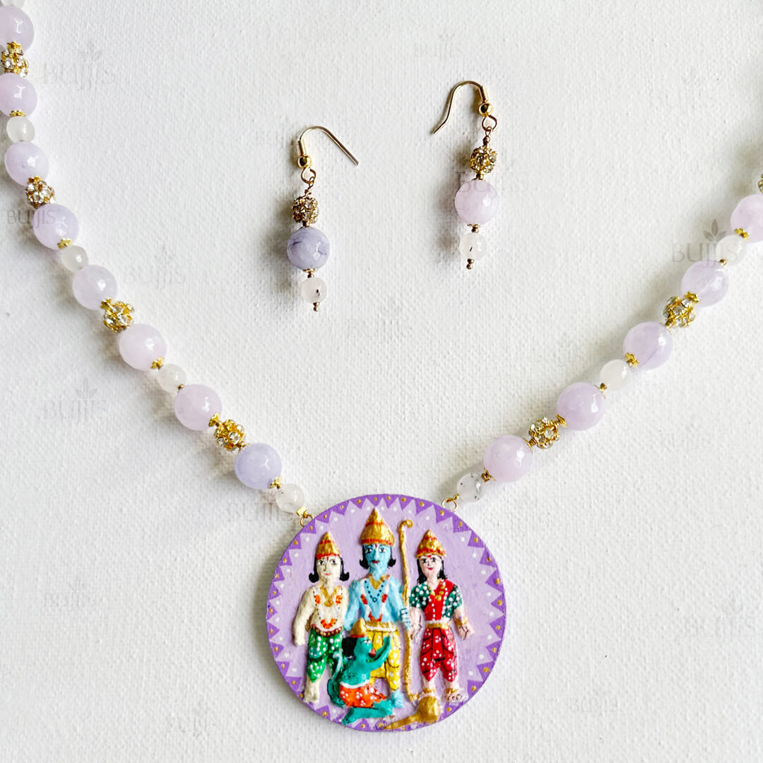 Front View of Divine Union necklace by Bujjis with hand-painted Sita, Rama, and Lakshmana pendant on purple base, accented with jade beads.
