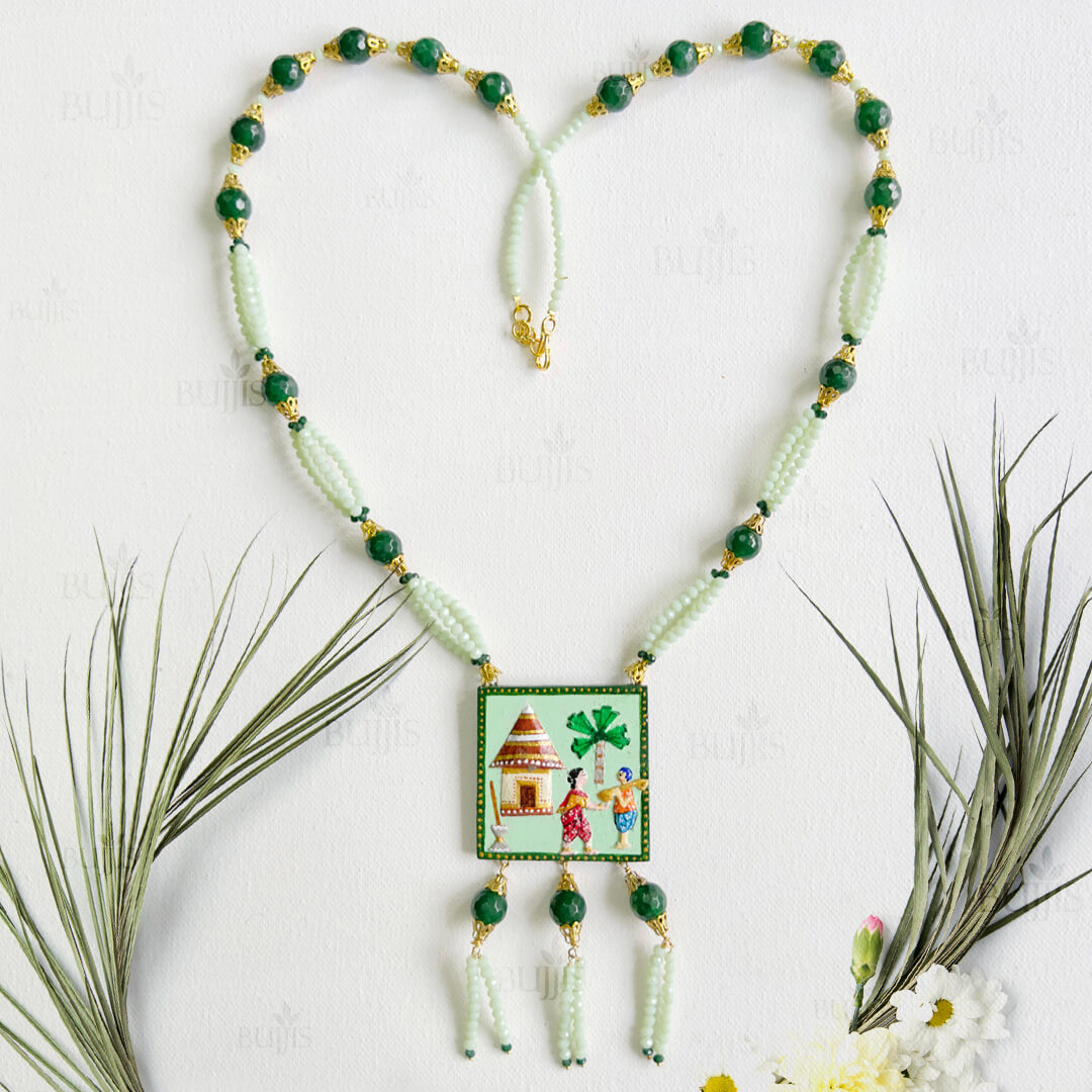 Front View of Rural Serenity necklace by Bujjis featuring a hand-painted village scene pendant, light and dark green beads, and gold detailing.