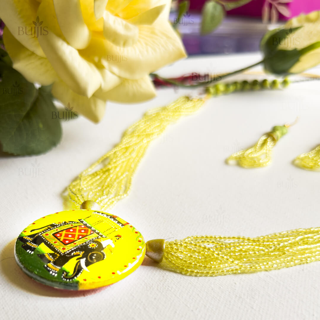 Side View of Royal Ambari necklace by Bujjis with 3D elephant pendant, hand-painted Kondapalli style, and yellow synthetic beads.