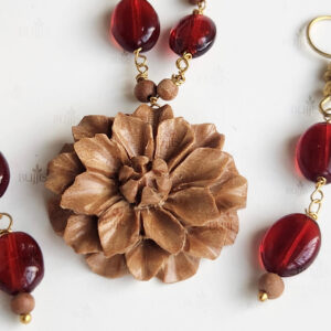 Verdant Petal necklace by Bujjis with carved wooden flower pendant, red beads, and gold accents.