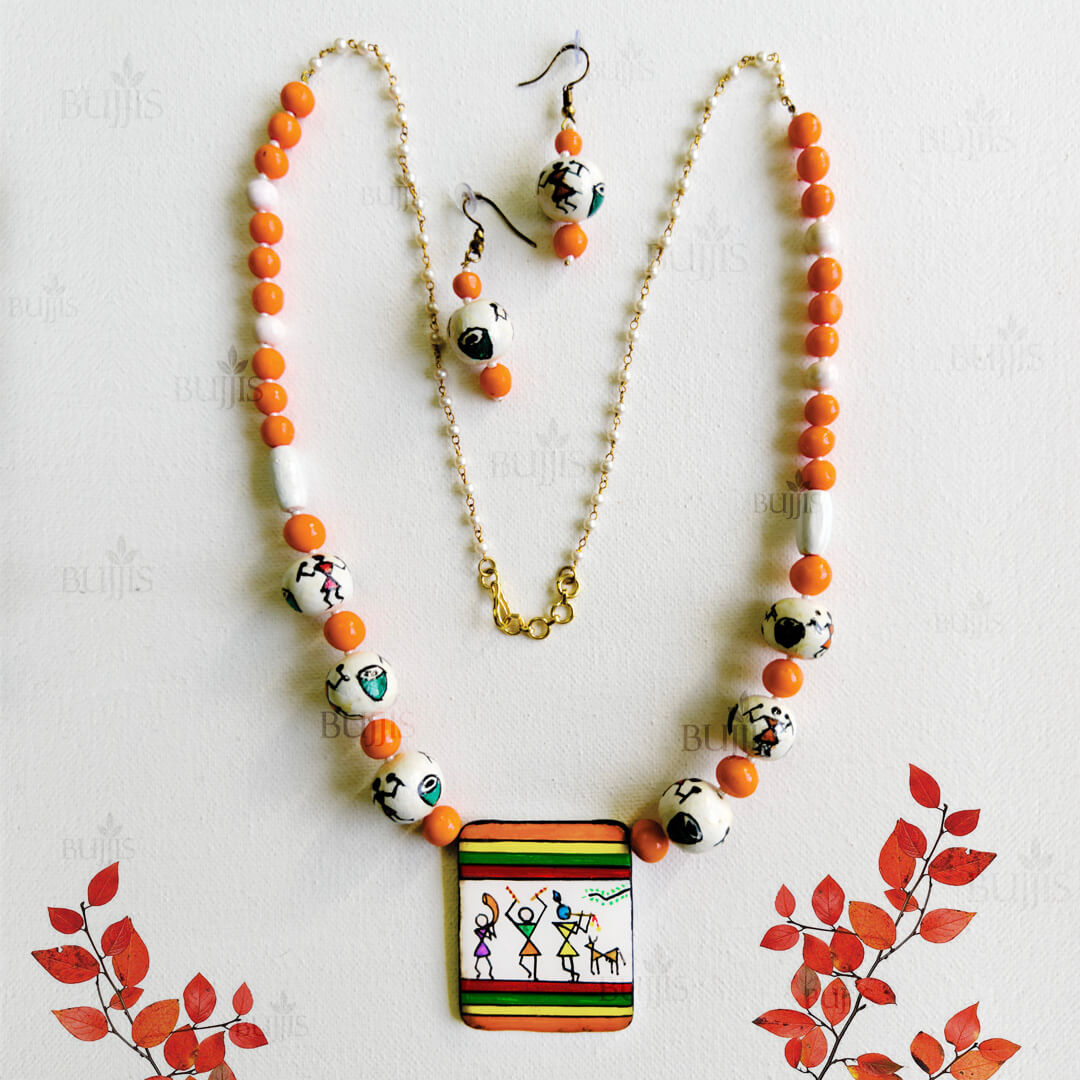 Rhythm Bloom handcrafted necklace and earring set with orange beads and hand-painted tribal dance pendant."
