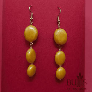 Golden Bead Drop Earrings with cascading design on red background – handcrafted lightweight jewelry by Bujjis.