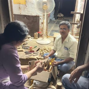 A conversation between a Bujjis team member and an artisan, discussing designs for wearable Indian art jewellery."